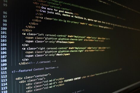 Image  of a computer screen with HTML code scrolling down.