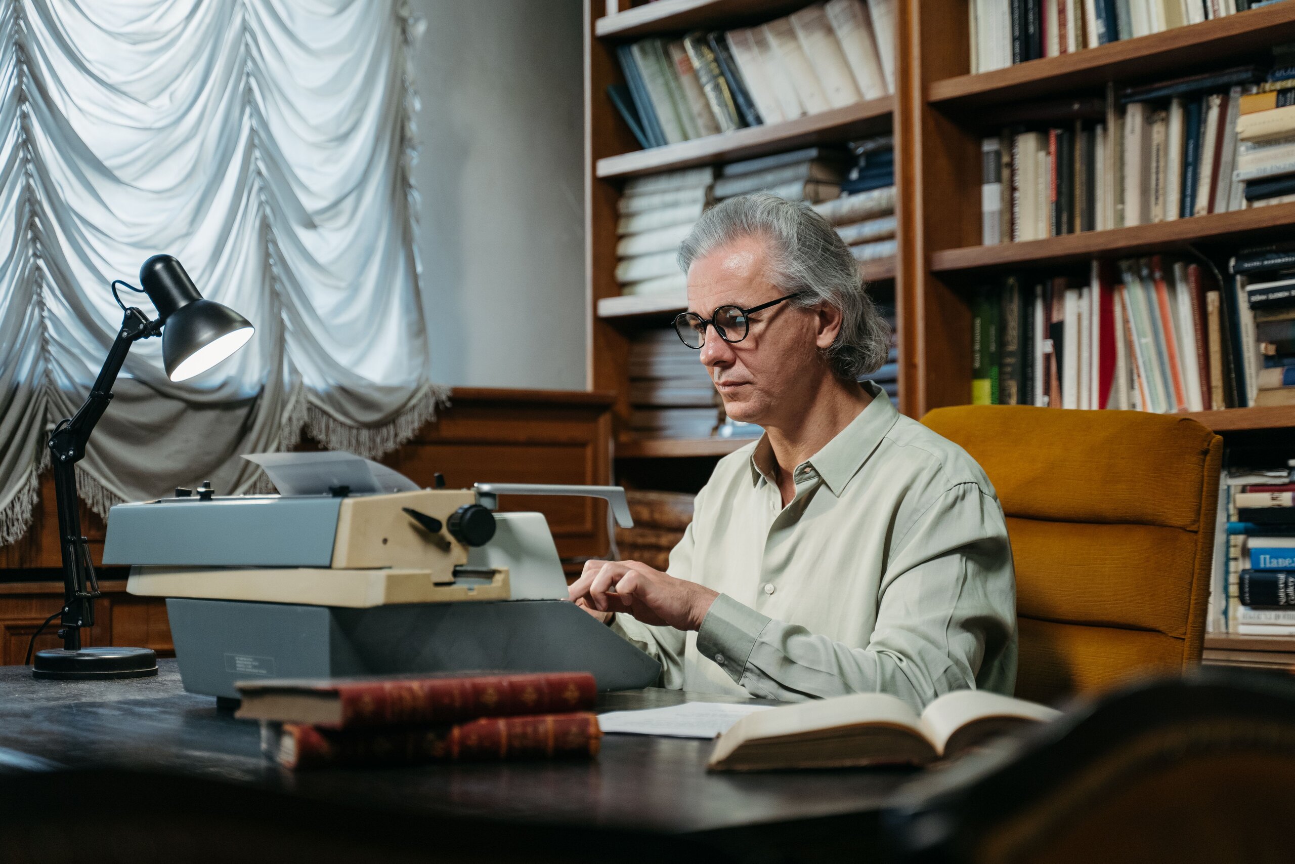 Authors Older man writing behind a desk